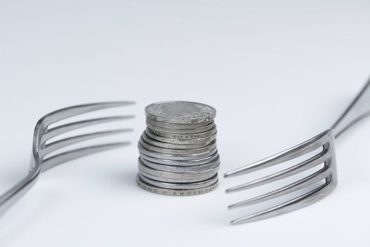 Conceptual representation of financial greed by two forks and coins
