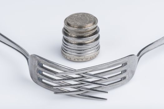 Conceptual representation of financial greed by two forks and coins
