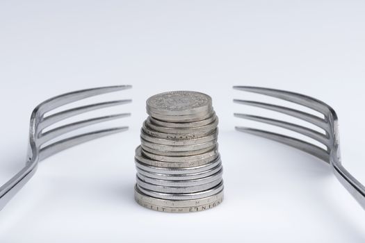 Conceptual representation of financial greed by two forks and coins
