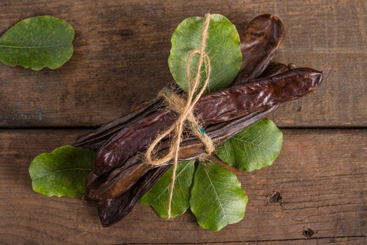 Raw fruits Carob on old wooden background