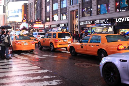 New York, USA - May 20, 2013: taxi's at Time Square at night in the rain. The site is regarded as the world's most visited tourist attraction with nearly 40 million visitors annually.