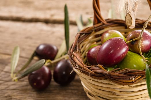 fresh olives in a basket, placed on a rustic wooden table. Olives from Sicily, Italy
