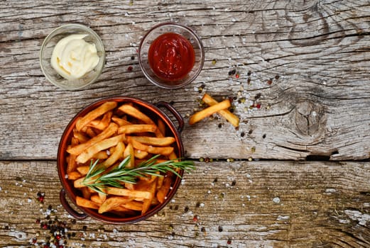 bowl of chips with salt and pepper on a wooden rustic.