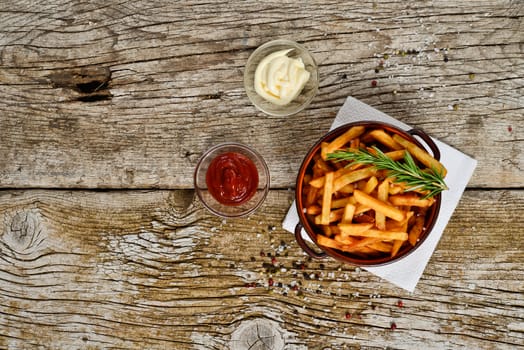 bowl of chips with salt and pepper on a wooden rustic.