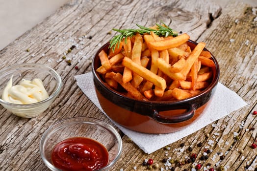 bowl of chips with salt and pepper on a wooden rustic.