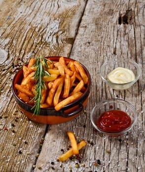 bowl of chips with salt and pepper on a wooden rustic.