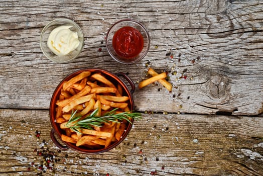 bowl of chips with salt and pepper on a wooden rustic.