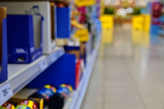 Blurred section at retail store in Europe. Aisle in local supermarket, defocused background.