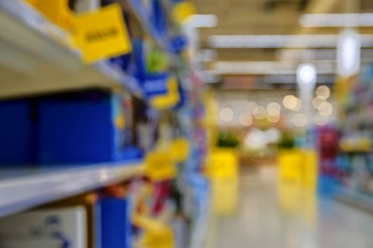 Blurred section at retail store in Europe. Aisle in local supermarket, defocused background.