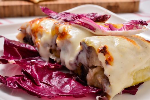 Italian cuisine. Cannelloni with radicchio and Taleggio cheese fondue