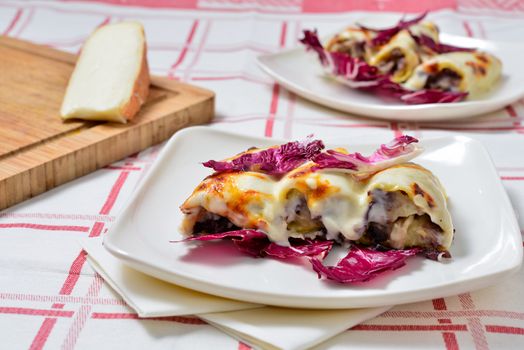 Italian cuisine. Cannelloni with radicchio and Taleggio cheese fondue