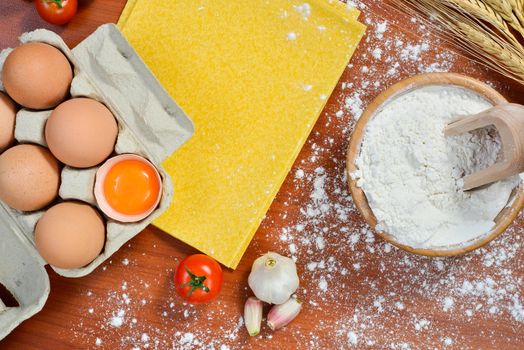 Egg noodles with ingredients on wooden table.