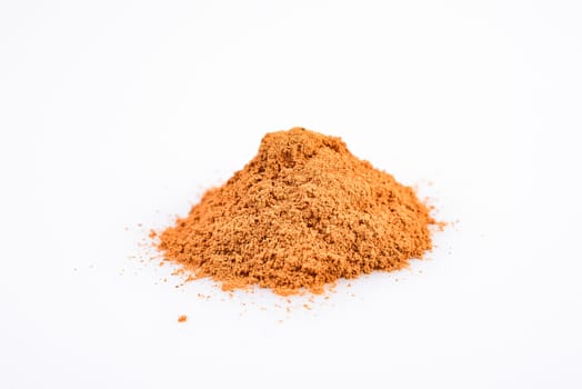 macro photograph of cinnamon sticks dry beside a teaspoon of ground cinnamon