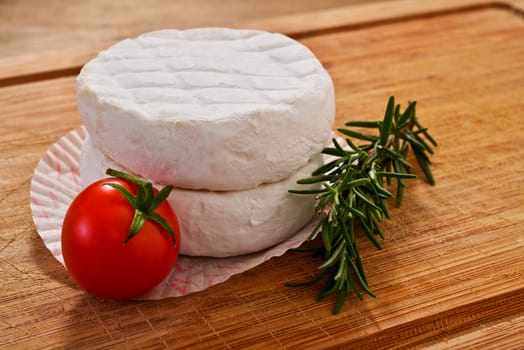 Italian tomino cheese on a wooden chopping board, italian appetizer