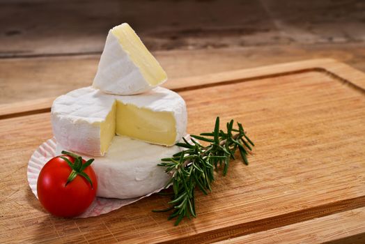 Italian tomino cheese on a wooden chopping board, italian appetizer
