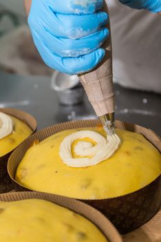 Pastry chef drops sugar icing on a panettone