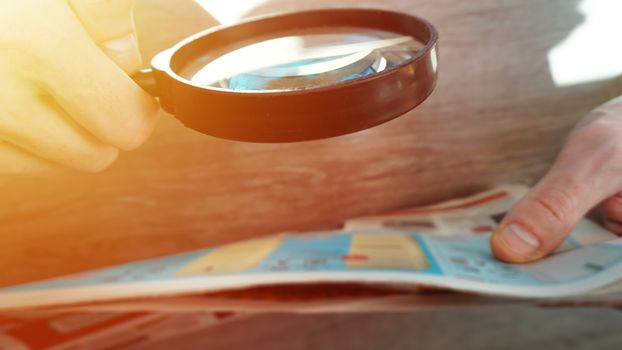 Businessman hand document and magnifier in office.