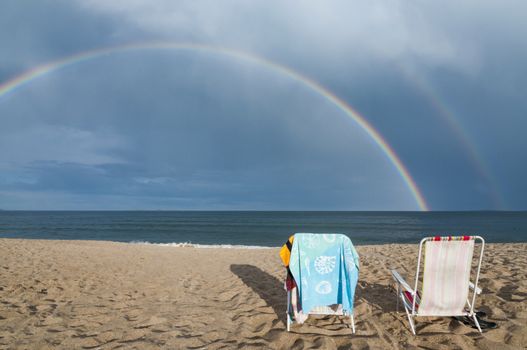 Chairs and rainbow on the beach in Maine, Usa