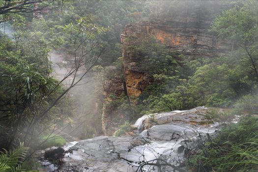 Water fed by the Jamison Creek  flows over the cliff edge at Wentworth Falls for a drop of around 187 metres to the bottom of the valley