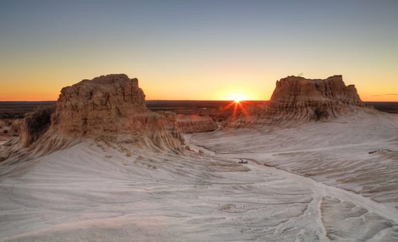 Sunset on the far horizon through raised desert formations at Mungo National Park in Australia