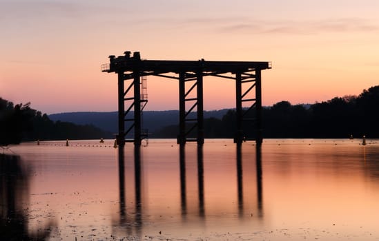 Sunset and silhouettes with reflections in the tranquil waters.