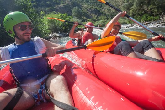 Two canoes collision in waters of a river, people smiling.