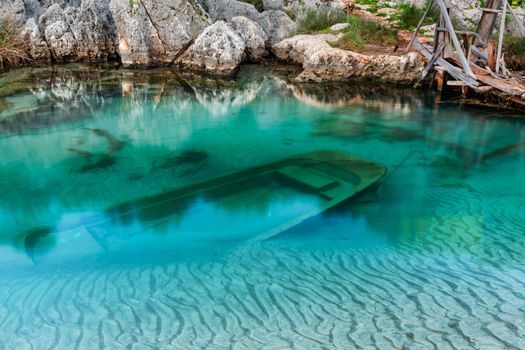 Sunken wooden boat in a little bay in Mediterranean Sea