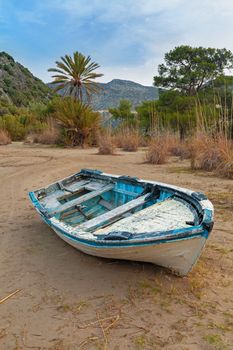 Abandoned old wooden boat on a beach sand