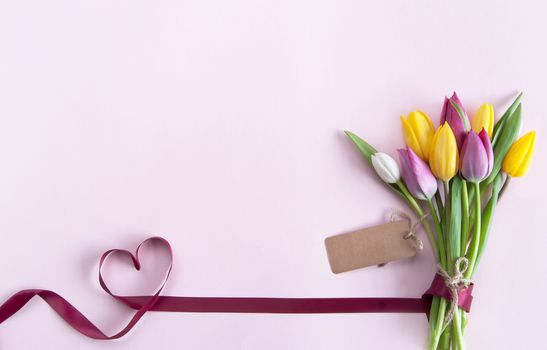 Heart shape ribbon attached to a bunch of flowers with label