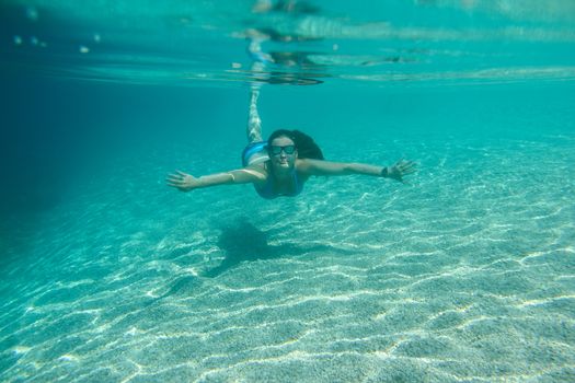 Woman swimming underwater, beautiful view of crystal clear transparent water of Mediterranean sea in Croatia