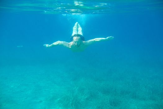 Man swimming underwater, beautiful view of crystal clear transparent water of Mediterranean sea in Croatia