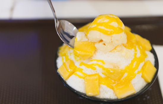 Closeup mango bingsu ice cream korea dessert  with spoon to eating, happy feeling