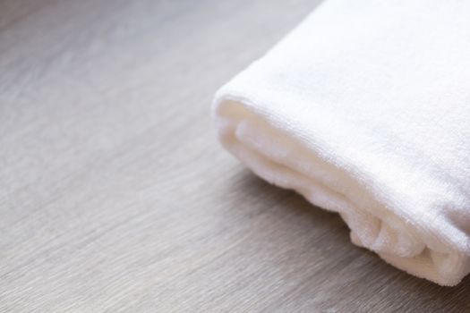 Closeup white towel on wood background, spa and relax concept, selective focus