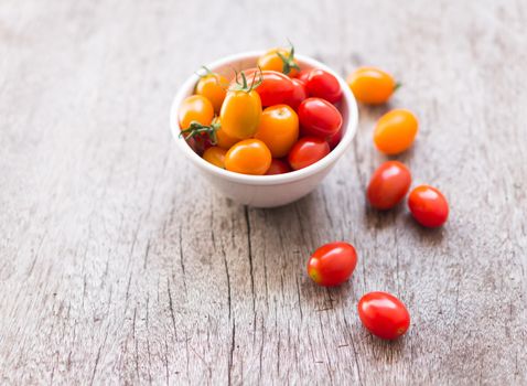 Fresh cherry tomatoes on wood background, raw food and vegetable, selective focus