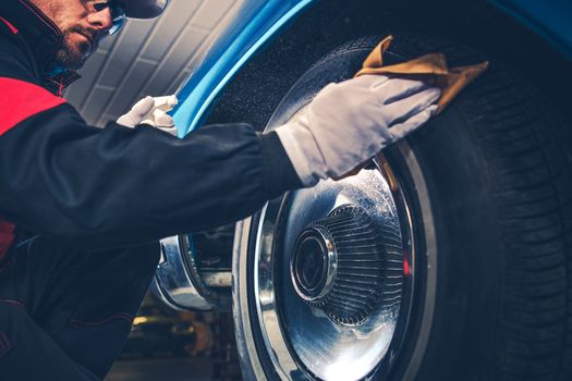 Caucasian Collector Taking Care of His American Classic Car. Chromed Wheels Cleaning.