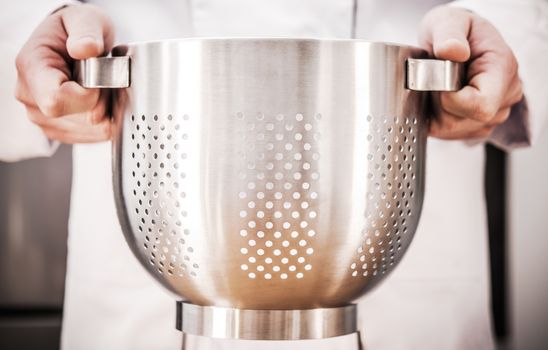 Chef with Stainless Steel Colander in Hands. Cooking and Kitchen Utensil Theme.