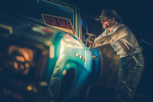 Western Wear Cowboy in His 30s Looking For a New Car. Looking Inside American Classic Car. For Sale Sign on the Windshield.