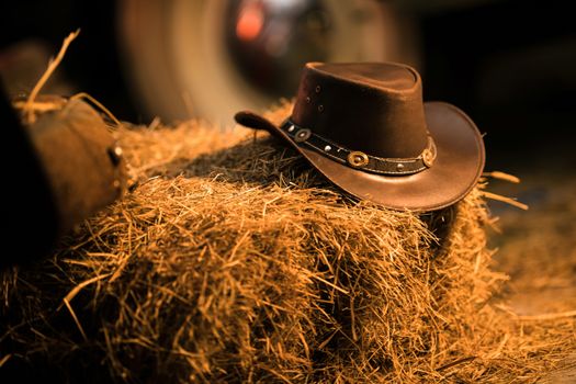 Leather Cowboy Hat on the Small Pile of Hay in the Old Barn. Western Wear and Wild West Concept.