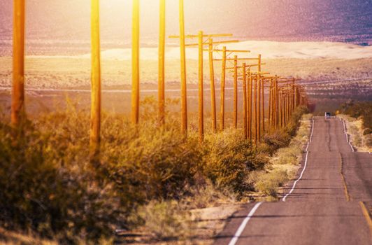 California Desert Highway with Aged Wood Electric Poles Along. Mojave Desert. United States of America.