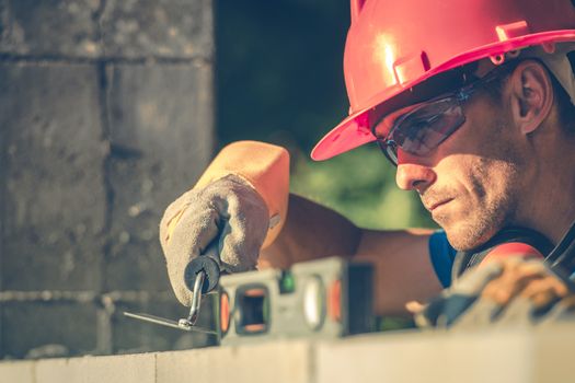 Caucasian Masonry Worker in Hard Hat. Construction Site Theme.