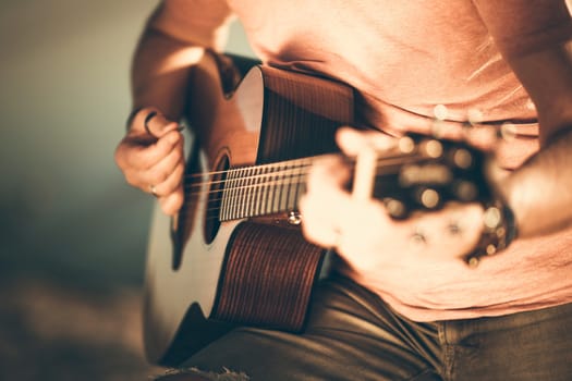 Caucasian Guitarist Playing Acoustic Guitar. Closeup Music String Instrument Theme.