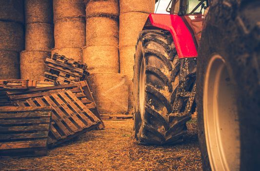 Modern Farming Equipment. Side of the Tractor and Hay Bales. Preparing Farm For the Winter.