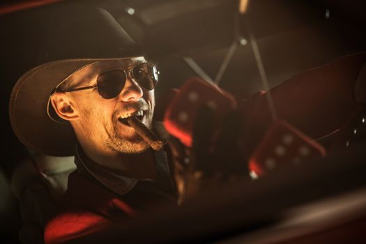 Happy Casino Jackpot Winner with Cigar Leaving Las Vegas in His Classic Car. Caucasian Men in His 30s Wearing Western Style Clothes Included Cowboy Hat.