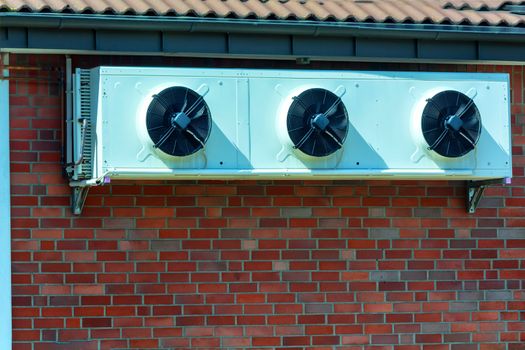 Compressor of an air conditioning mounted on a house wall.