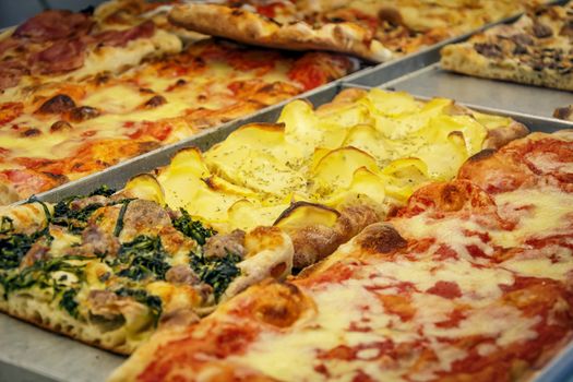 close-up view of a rectangular pizza slice stuffed with potatoes, tomato and cheese