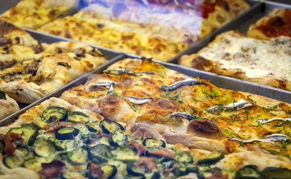 close-up view of a rectangular pizza slice stuffed with zucchini, anchovies and cheese