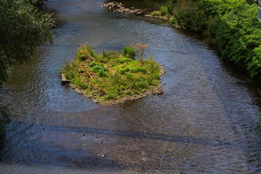 The river Wupper in Wuppertal, Germany with a small island in the river bed. Photographed from the suspension railway.