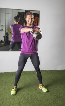 Man in his thirties, doing a half kettlebell swing