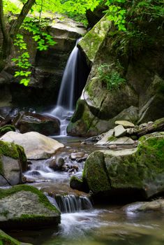 small waterfall among the rocks. beautiful in ancient woods