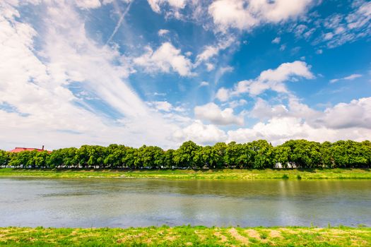 embankment of the river Uzh. beautiful summer scenery. longest european linden alley under the gorgeous cloudscape on a blue sky